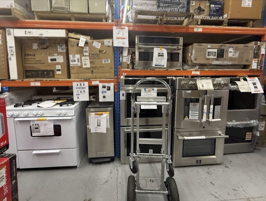 Row of appliances at ABC Home Outlet including ranges, microwaves, washers, and dishwashers